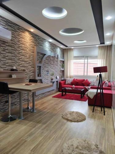 マラケシュにあるAppartement Calme a Marrakechのテーブルと赤いソファのあるリビングルーム