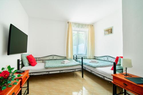 a living room with two beds and a window at Hotel Ostende in Chocerady
