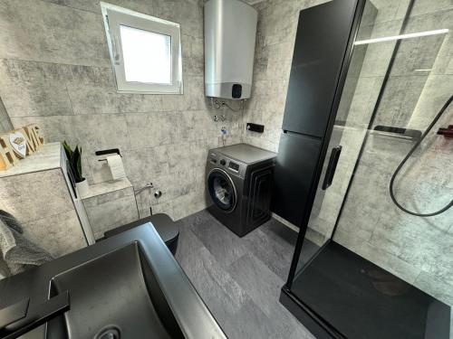 a bathroom with a washing machine and a sink at Ferienhaus Bilice - Pool beheizt - Fitness - Relax in Bilice
