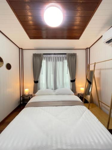 a bedroom with a large bed and a window at Anna River Home A1 in Ban Khlong Si