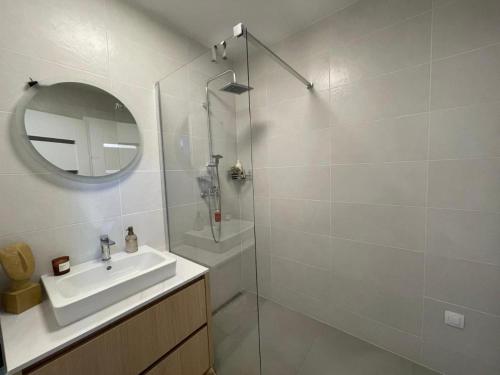 a white bathroom with a sink and a mirror at PENATI GOLF Apartment in Šajdíkove Humence