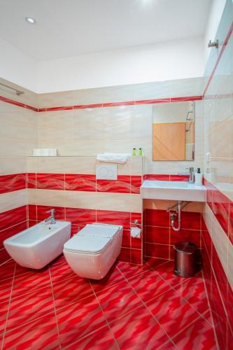 a red bathroom with a sink and a toilet at Hotel Ostende in Chocerady