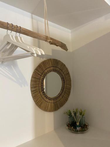 a mirror hanging on a wall with a plant at Seaside Akrata's House in Paralía Akrátas