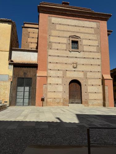 a tall building with a door and a window at Apartamentos Peñaflor in Guadix