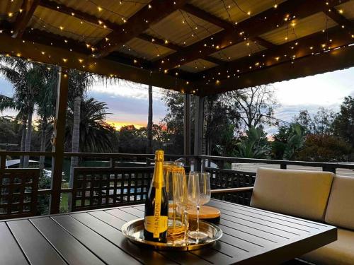 a bottle of champagne and glasses on a table on a balcony at East Hills Waterfront Bliss in East Hills