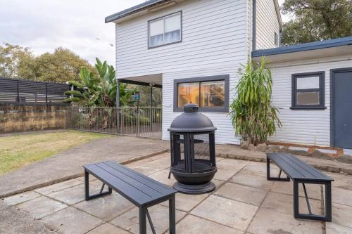 two benches and a street light in front of a house at East Hills Waterfront Bliss in East Hills