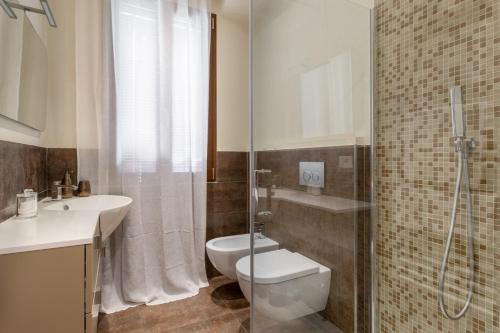 a bathroom with a toilet and a sink and a shower at DUOMO Murano Apartment with Canal view in Murano