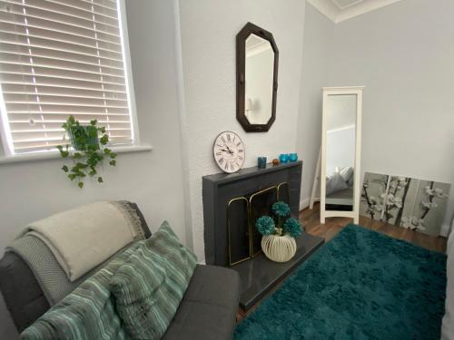 a living room with a couch and a mirror at Spacious Double Studio-style room in Orpington
