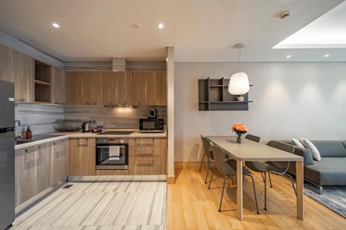 a kitchen and living room with a table and a couch at Sherwood Suites in Ho Chi Minh City
