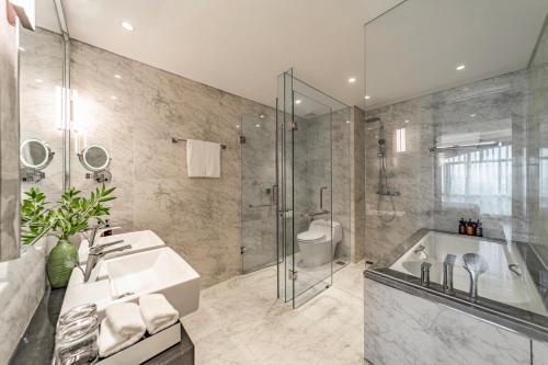 a bathroom with a tub and a sink and a shower at Sherwood Suites in Ho Chi Minh City