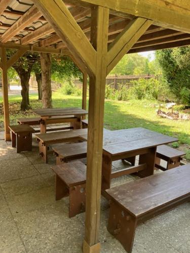 a group of picnic tables under a wooden pavilion at Ubytování ve vinici in Hustopeče