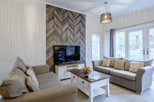 a living room with a couch and a tv at Best Western Plus Kenwick Park Hotel in Louth