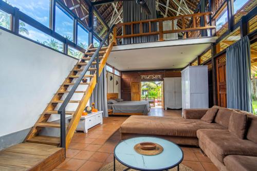 a living room with a couch and a staircase at L'autentiko in Pulukan