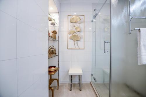 科隆Stylisch und Schick, neue Wohnung, U-Bahn 2 Minuten的一间带玻璃淋浴和凳子的浴室