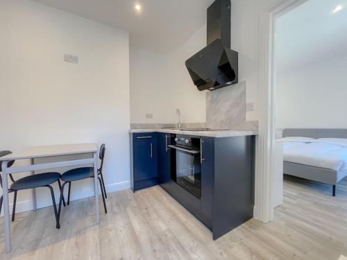 a kitchen with a desk and a table and a bed at Britannia Road in Great Yarmouth