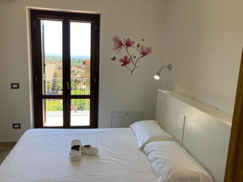 a bedroom with a white bed with a window at SIMPLY INN close to TIVOLI in Marcellina
