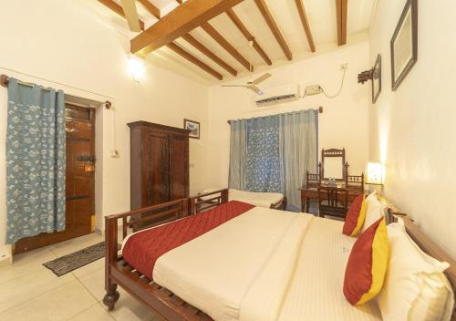 a bedroom with a bed and a chair in it at Dumas Guest House in Puducherry