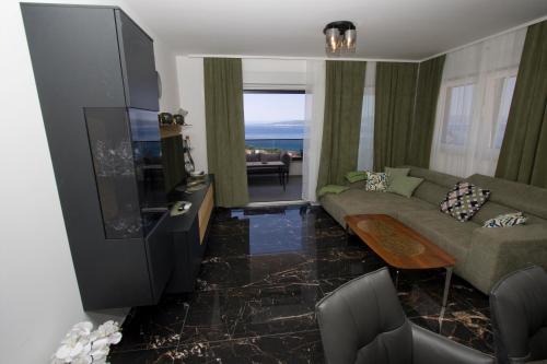 un salon avec un canapé et une télévision à écran plat dans l'établissement Top5, à Baška Voda