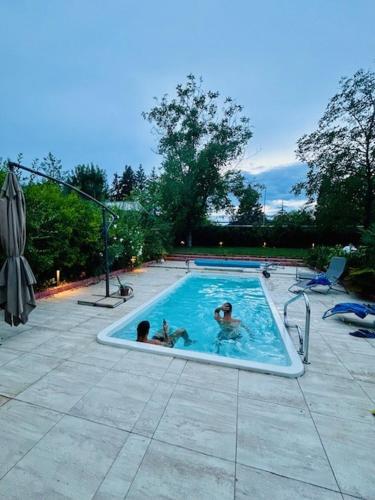 two people are swimming in a swimming pool at Funny Füred in Balatonfüred