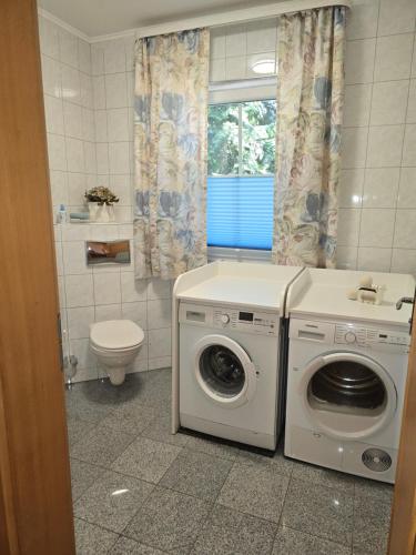 a bathroom with a washing machine and a toilet at Domizil Resi in der Fränkischen Schweiz bei Bayreuth in Mistelgau
