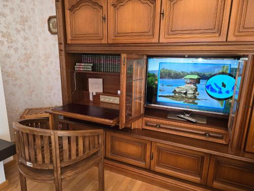 a television in a wooden entertainment center at Domizil Resi in der Fränkischen Schweiz bei Bayreuth in Mistelgau