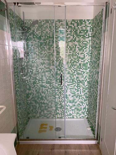 a bathroom with a shower with green tiles at Studio Lido 10 in Lido delle Nazioni