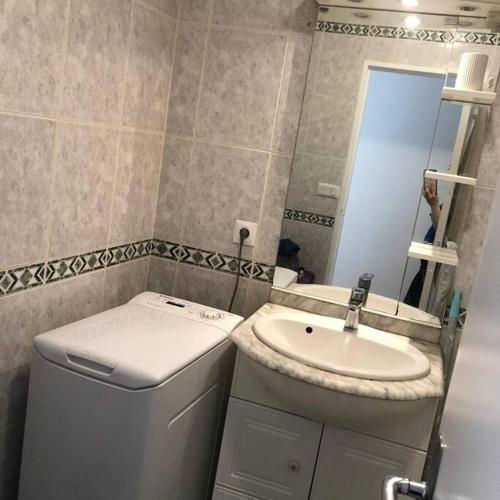 une salle de bain avec un lavabo, des toilettes et un miroir dans l'établissement appartement F3 proche métro 7, à Ivry-sur-Seine