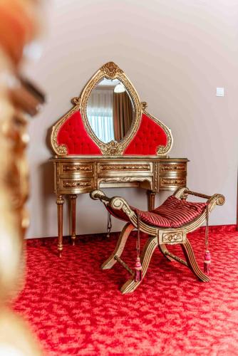 a dressing table with a mirror and a chair at Casa ANTIC in Baile Felix