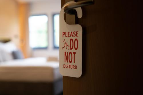 a sign on a door that says please do not disturb at Resort Špindl in Špindlerův Mlýn