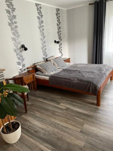 a bedroom with a bed and a potted plant at Brīvdienu apartaments Melnsilā in Melnsils