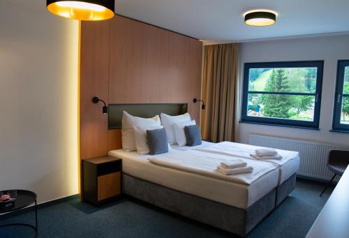 a hotel room with a bed and a window at Resort Špindl in Špindlerův Mlýn