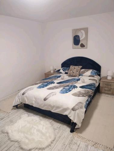 a bedroom with a bed with a blue head board at Gornji Milanovac Apartment in Gornji Milanovac