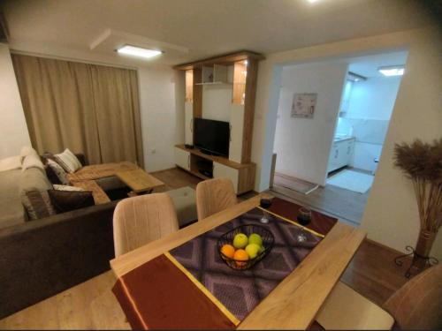 a living room with a table with a bowl of fruit on it at Gornji Milanovac Apartment in Gornji Milanovac
