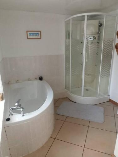une salle de bain blanche avec une baignoire et une douche dans l'établissement Gite de campagne très calme, à Ménil-Hubert-sur-Orne