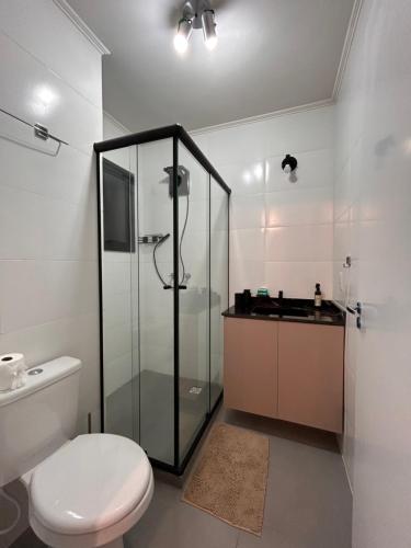 a bathroom with a glass shower and a toilet at Ap Novo Parque Anchieta - Top in Pelotas