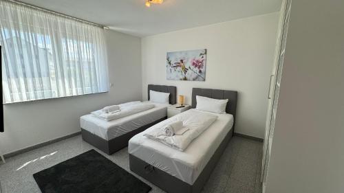 una camera da letto con due letti e una finestra di Moderne Wohnung für bis zu 8 Personen mit großem Balkon a Niestetal