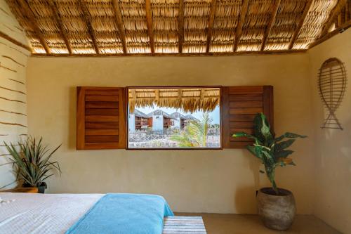 a bedroom with a bed and a window at São Francisco Ecopousada in Guriú