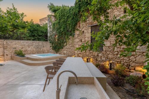 a patio with a table and chairs next to a building at Lemon Garden Villa in Rethymno