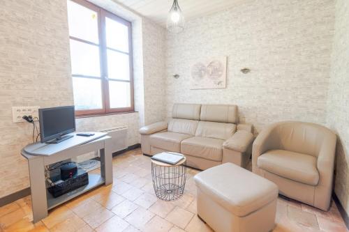 ein Wohnzimmer mit Sofa und Fernseher in der Unterkunft La petite maison sur la colline in Nazelles