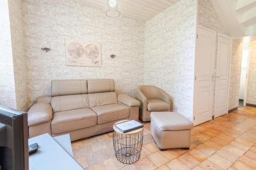 un salon avec un canapé et une chaise dans l'établissement La petite maison sur la colline, à Nazelles-Négron