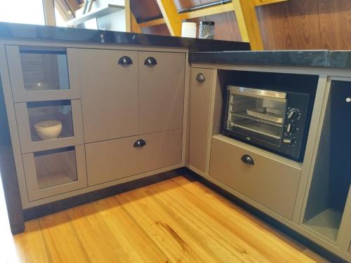 a kitchen with a counter top with a oven at Chalés Paraíso do Lago in Itá