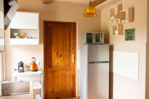 a kitchen with a refrigerator and a wooden door at Dzika Foka Wiosłowa 49 in Gdańsk