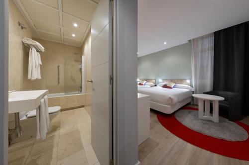 a hotel room with a bed and a bathroom at Hotel Pasarela in Seville