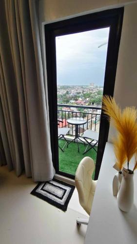 a room with a view of a balcony with a table at Sky High Suites Royal Ocean Crest Mactan in Lapu Lapu City