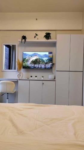 a bedroom with a television and a white cabinet at Sky High Suites Royal Ocean Crest Mactan in Lapu Lapu City