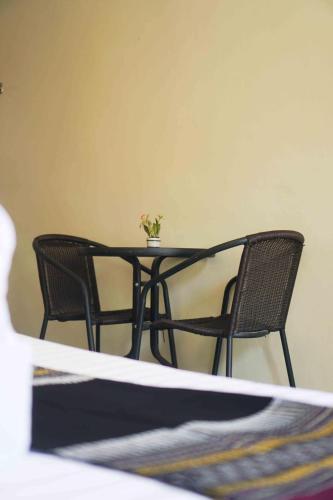 a table with two chairs and a table with a plant on it at โรงแรมเพิ่มพูล 1 in Nan