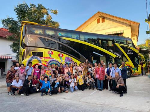 a group of people standing in front of a bus at โรงแรมเพิ่มพูล 1 in Nan
