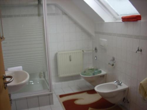 a bathroom with a sink and a toilet and a tub at Hotel Garni Zentral in Willich