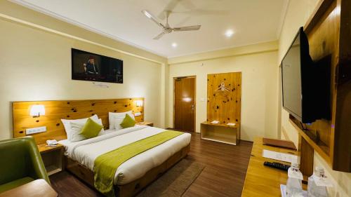 a bedroom with a bed and a flat screen tv at Crown Himalaya in Leh