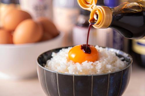 an egg being being poured into a bowl of rice at THE SINGULARI HOTEL & SKYSPA at UNIVERSAL STUDIOS JAPAN in Osaka